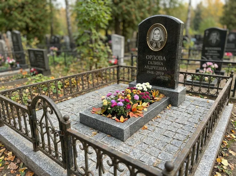 Благоустроенное захоронение с гранитной плиткой, оградой и цветником в Ставрополе