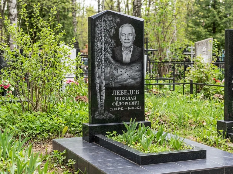 Памятник с гравировкой берёзы: вертикальная стела со скошенным верхом — берёза и стая птиц в небе, гранитный цоколь с тёмной плиткой, работа «Лебедев» в Ставрополе