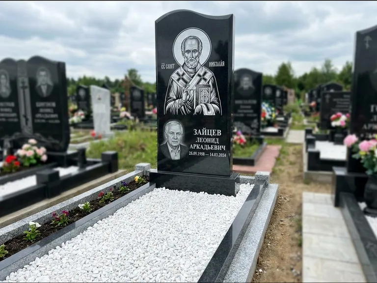 Памятник с гравировкой иконы: стела с крестообразным навершием — икона в резной рамке-киоте, газон без ограды, стриженая трава, работа «Раевская» в Ставрополе