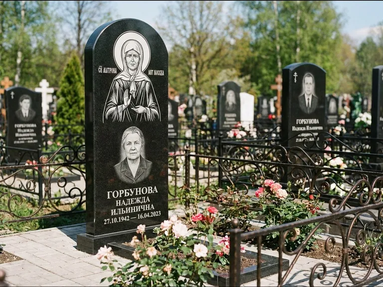 Памятник с гравировкой иконы: стела с арочным верхом и киотом под образ — гравировка образа Матроны Московской, гранитный цоколь с тёмной плиткой, работа «Ковалёв» в Ставрополе