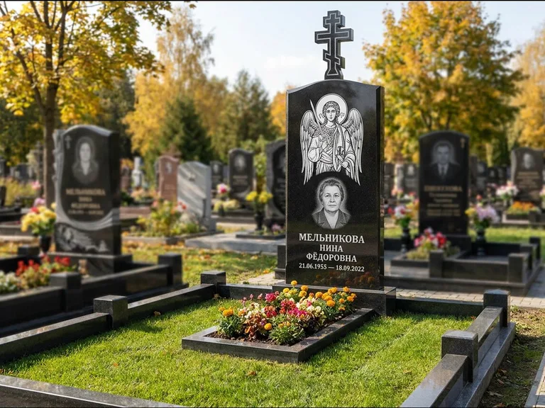Памятник с гравировкой иконы: округлая стела-медальон с ликом — гравировка Богородицы «Семистрельная», луговые травы и полевые цветы за участком, работа «Гущин» в Ставрополе