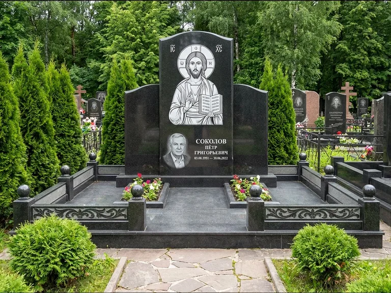 Памятник с гравировкой иконы: широкая горизонтальная лежачая плита-стела — икона в резной рамке-киоте, серая гравийная отсыпка с бордюром, работа «Богданова» в Ставрополе