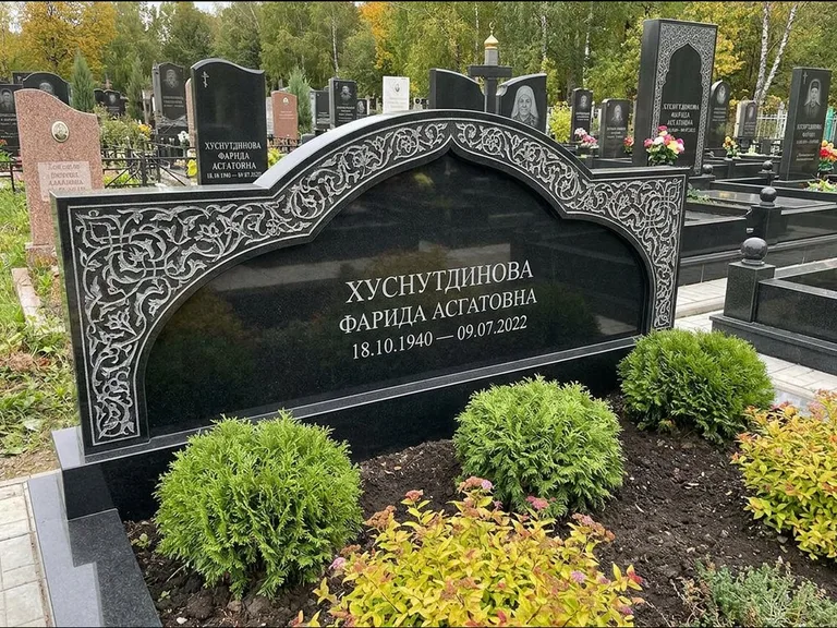 Мусульманский памятник: вытянутая горизонтальная семейная стела с аркой — белая гравировка силуэта мечети с минаретами, участок с декоративными кустами, работа «Зарипова» в Ставрополе