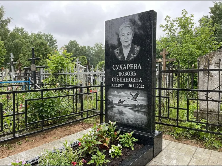 Памятник с гравировкой журавлей — гравировка пары журавлей над гладью озера в нижней части, работа «Сухарева» в Ставрополе