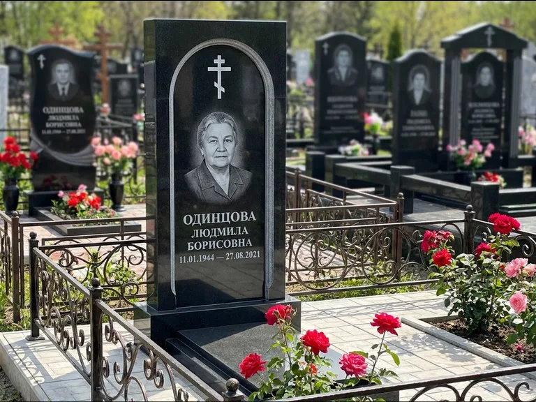 Памятник из чёрного гранита — скромная невысокая стела с крестом с терновым венцом, работа «Лаврентьева» в Ставрополе