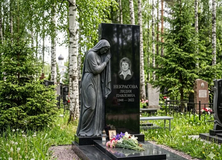 Гранитная фигура скорбящего мужчины у чёрной стелы в Ставрополе