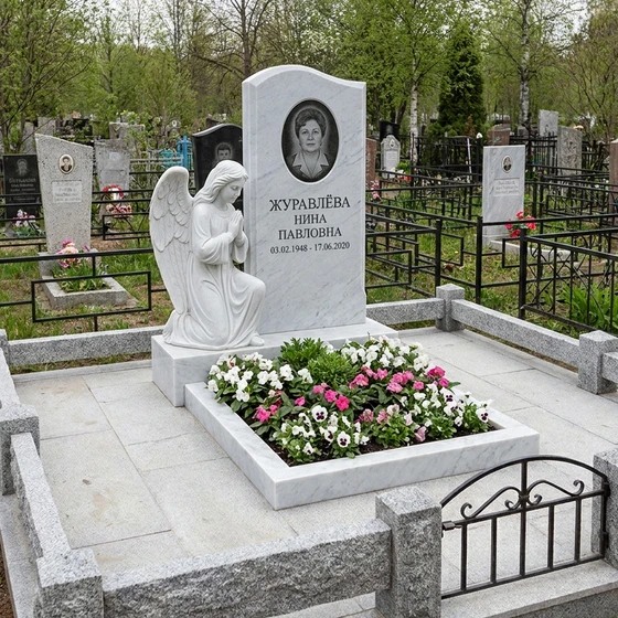 Резной памятник из белого мрамора в виде молящегося ангела